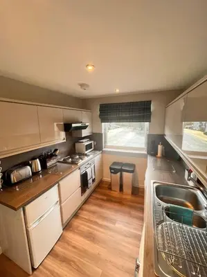 a small kitchen with a sink and a stove at Gleneagles Apartment in Auchterarder