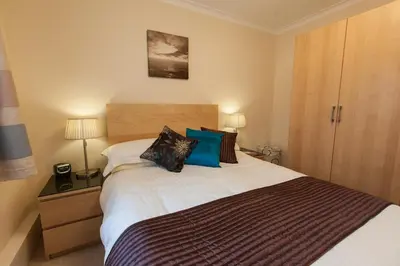 a bedroom with a large bed with blue pillows at Cedars Apartment in Kirn