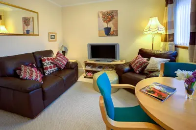 a living room with a couch and a table at Cedars Apartment in Kirn