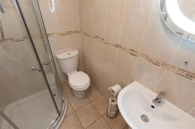 a bathroom with a toilet and a shower and a sink at Cedars Apartment in Kirn