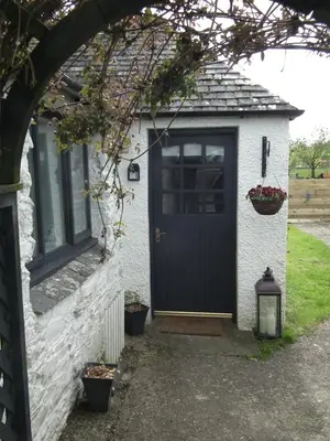 a house with a blue door and a window at Borrowmoss Bothy, Charming & Characterful property, Wigtown in Wigtown