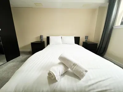 a bedroom with a bed with two towels on it at Duplex Apartment in Glasgow in Glasgow
