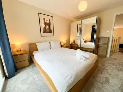 a bedroom with a large white bed and a mirror at Duplex Apartment in Glasgow in Glasgow