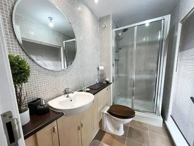 a bathroom with a sink and a toilet and a mirror at Duplex Apartment in Glasgow in Glasgow