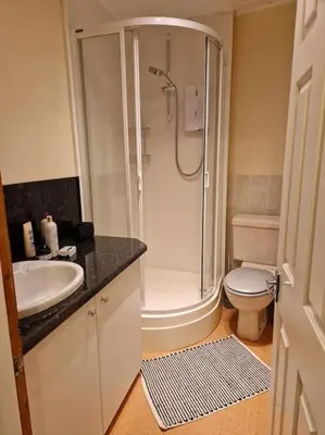 a bathroom with a shower and a toilet and a sink at The Old Post Office House in Perth