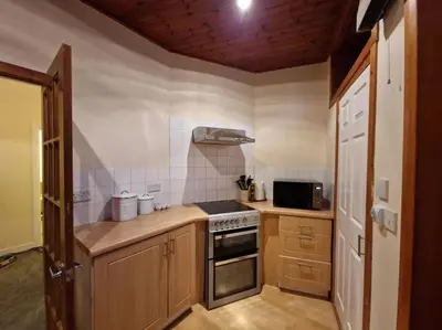 a kitchen with a stove and a microwave at The Old Post Office House in Perth