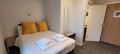 a bedroom with a bed with towels on it at Hamish Apartment in Stirling