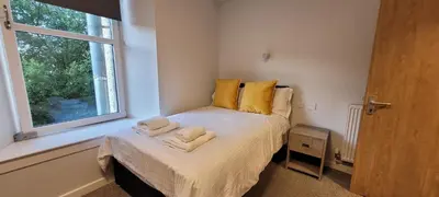 a bedroom with a bed with towels on it at Hamish Apartment in Stirling