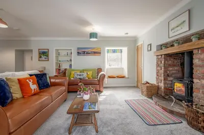 a living room with a couch and a fireplace at No7 Drummond Street, 2 bedrooms, Comrie in Comrie