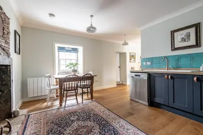 a kitchen with a table and chairs and a kitchen with blue cabinets at No7 Drummond Street, 2 bedrooms, Comrie in Comrie