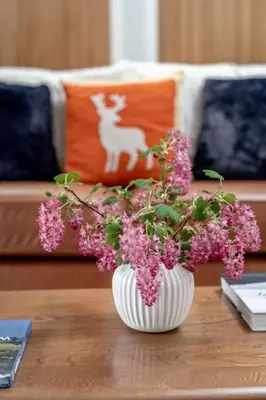 a white vase with pink flowers on a table at No7 Drummond Street, 2 bedrooms, Comrie in Comrie