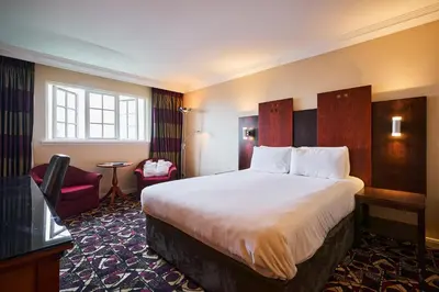 a hotel room with a large bed and a window at Stirling Highland Hotel- Part of the Cairn Collection in Stirling