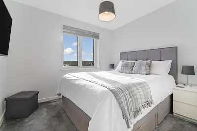 a white bedroom with a large bed and a window at Scenic getaway, open plan home! 2bed park for free in Eaglesham