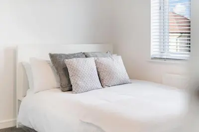 a white bed with pillows on top of it at Scenic getaway, open plan home! 2bed park for free in Eaglesham