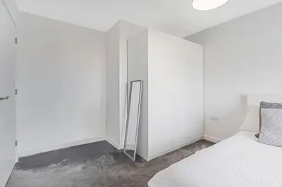a bedroom with white walls and a bed and a closet at Scenic getaway, open plan home! 2bed park for free in Eaglesham
