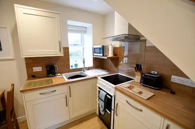 a small kitchen with a sink and a stove at Argyll House The Byre in Salen