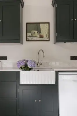 a kitchen with black cabinets and a sink at Shepherds Cottage, Pentland Hills in Nine Mile Burn