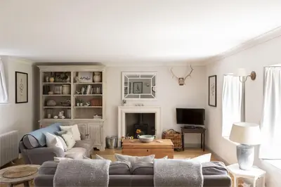 a living room with a couch and a tv at Shepherds Cottage, Pentland Hills in Nine Mile Burn