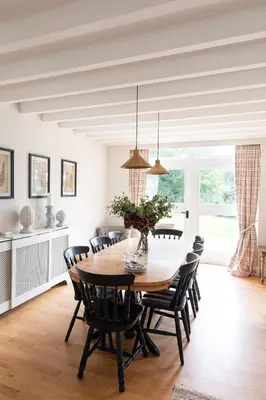 a dining room with a wooden table and chairs at The Coach House, Pentland Hills in Nine Mile Burn