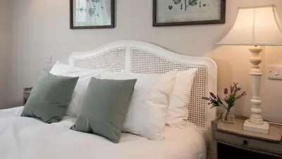 a bedroom with a white bed with white pillows at The Coach House, Pentland Hills in Nine Mile Burn