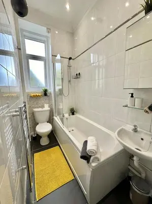 a white bathroom with a toilet and a sink at Dumbarton cosy home, Loch Lomond in Dumbarton