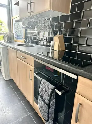 a kitchen with a sink and a black oven at Dumbarton cosy home, Loch Lomond in Dumbarton