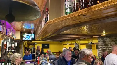 a group of people sitting at a bar at Kingarth Hotel in Kilchattan