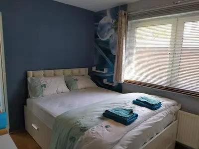 a bedroom with a bed with two towels on it at Double Ensuite room, 1-minute walk to bus stop in Edinburgh