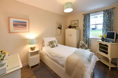 a small bedroom with a bed and a window at Ladyland Cottage in Maybole in Maybole