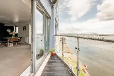 a house with a balcony with a view of the ocean at Calming Sea View City Apartment in Edinburgh