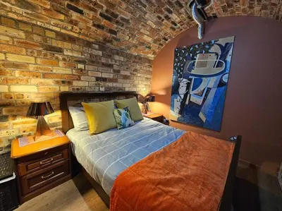 a bedroom with a brick wall and a bed at The Armoury: Stylish WW1 Bunker in North Queensferry