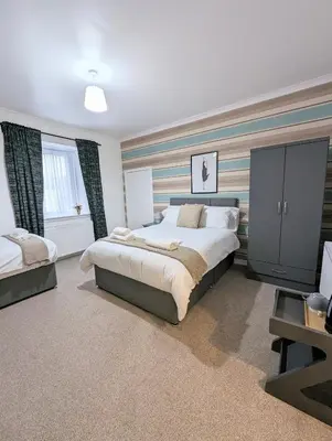 a large bedroom with a large bed and a window at Erradale in Campbeltown