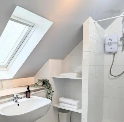 a white bathroom with a sink and a window at Erradale in Campbeltown