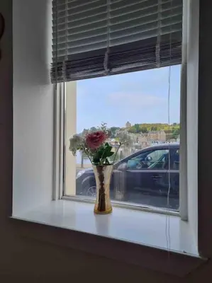a vase of flowers sitting on a window sill at Penlea ~ 1 bedroom Flat with Harbour view in Tarbert