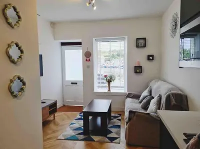 a living room with a couch and a table at Penlea ~ 1 bedroom Flat with Harbour view in Tarbert