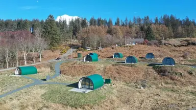 a group of green domes in a field at Port Nan Gael Pods in Pennyghael