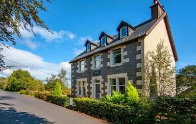 a large brick house on the side of a road at Room 1, Loch Etive House, Connel near Oban in Connel