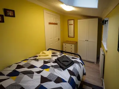 a bedroom with a bed with a black and white comforter at Pirnmill Home with a view in Pirnmill
