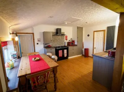 a kitchen with a wooden table in a room at Pirnmill Home with a view in Pirnmill