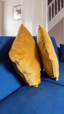 two yellow pillows sitting on top of a blue couch at Airth House in Airth