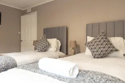 two beds with white sheets and pillows in a room at Airth House in Airth