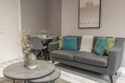 a living room with a couch and a table at Castlemilk Apartment in Glasgow