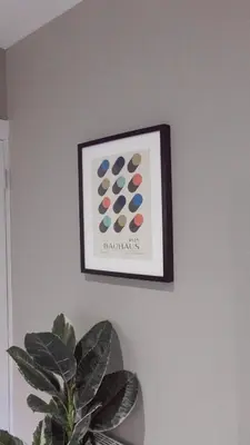 a picture hanging on a wall with a potted plant at Castlemilk Apartment in Glasgow