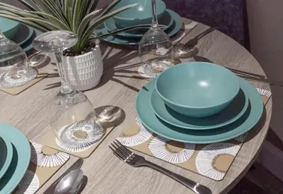 a table with a blue bowl and plates on it at Castlemilk Apartment in Glasgow