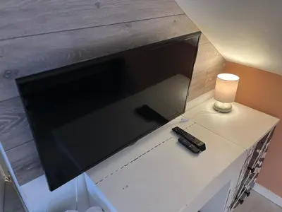 a large flat screen tv sitting on top of a table at Mini hotel with home facilities in Hamilton West in High Blantyre