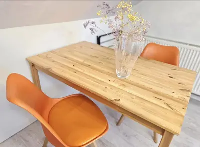 a wooden table with a vase with flowers in it at Mini hotel with home facilities in Hamilton West in High Blantyre