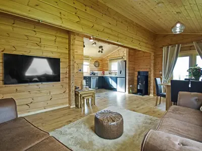 a living room with a large flat screen tv on a wooden wall at Stag Lodge - Uk46921 in Falkirk