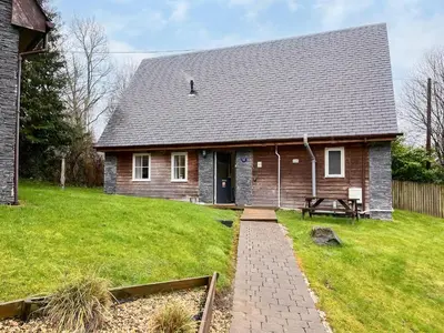 a house with a picnic table in front of it at Ptarmigan Lodge in Balmaha