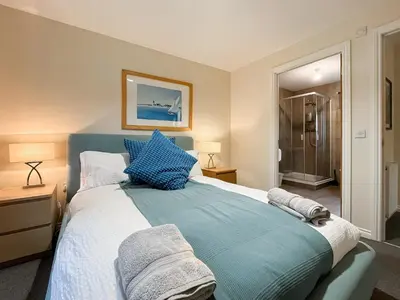 a bedroom with a large bed with blue pillows at Ptarmigan Lodge in Balmaha
