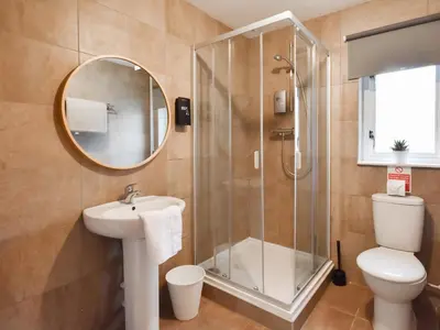 a bathroom with a shower and a toilet and a sink at Ptarmigan Lodge in Balmaha